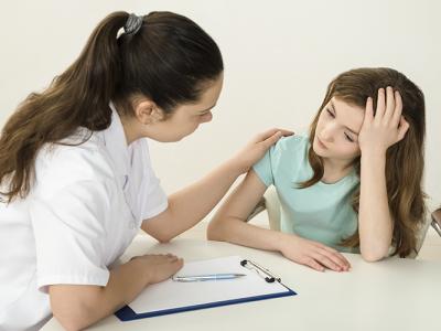 Imagem mostra uma menina sendo atendida por uma psicológa
