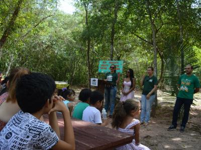 Imagem mostra alunos sentados no banco do zoológico