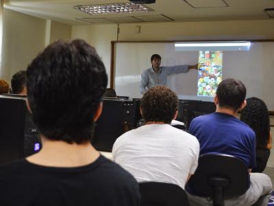 Imagem mostra pessoas assistindo a uma palestra