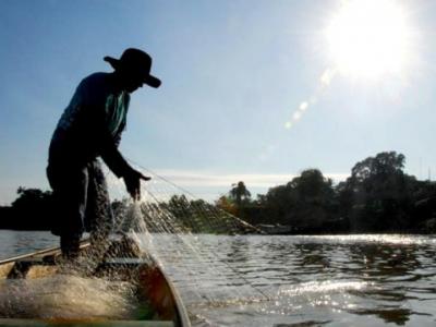 Imagem mostra um homem pescando com rede 