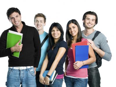 Imagem mostra alunos em pé segurando caderno