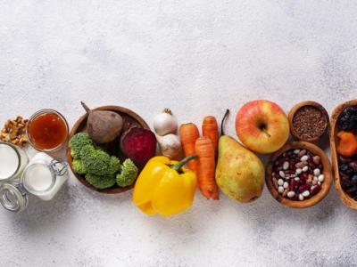 A imagem mostra frutas e verduras enfileiradas em um fundo branco