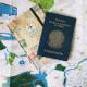 Imagem mostra um mapa, um caderno e um passaporte