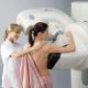 A imagem mostra uma mulher realizando o exame de mamografia